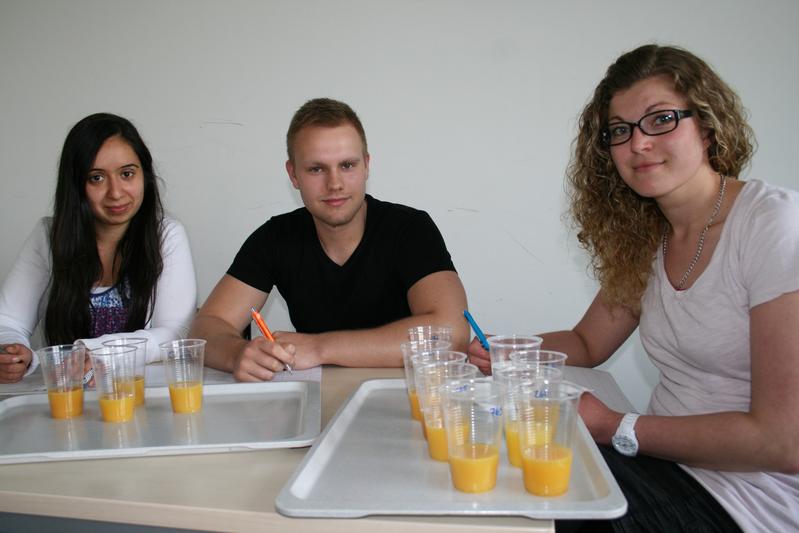 Emel Kumru, Nino Beisler und Isabell Haase (v.l.) beurteilen den Geschmack von Orangensäften verschiedener Hersteller.