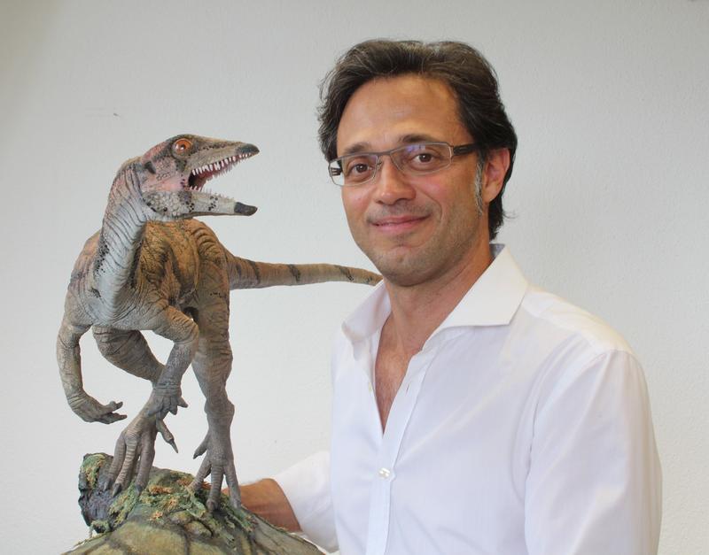 Prof. Marcelo Sánchez, Professor für Paläontologie der Universität Zürich, posiert mit einem Modell von Laquintasaura venezuelae, das Jorge Gonzales entworfen hat. 