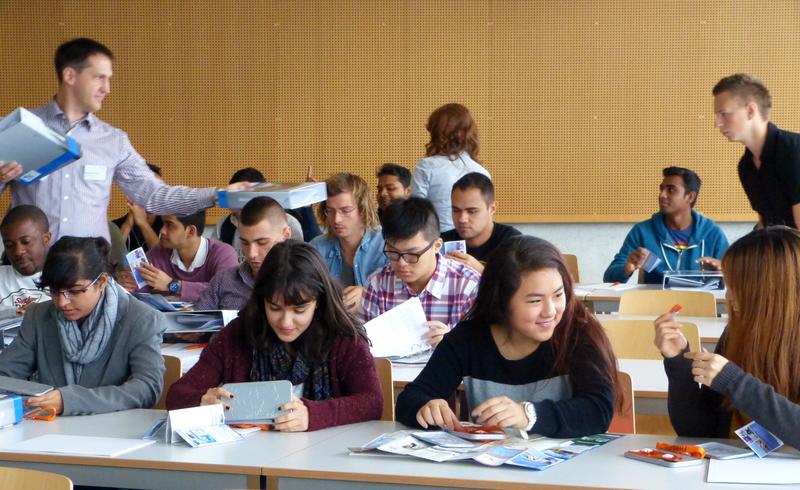 Der FHWS i-Campus-Projektleiter Stefan Hartmann (hinten li.) verteilt Informationen an die Studierenden des FHWS i-Campus. 