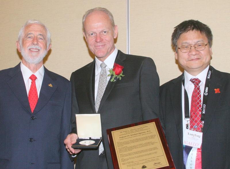 Prof. Reinhart Poprawe (middle) is honored with the 2014 Arthur L. Schawlow Award. Left: Peter Baker, LIA Executive Director, Right: LIA President Yongfeng Lu. 
