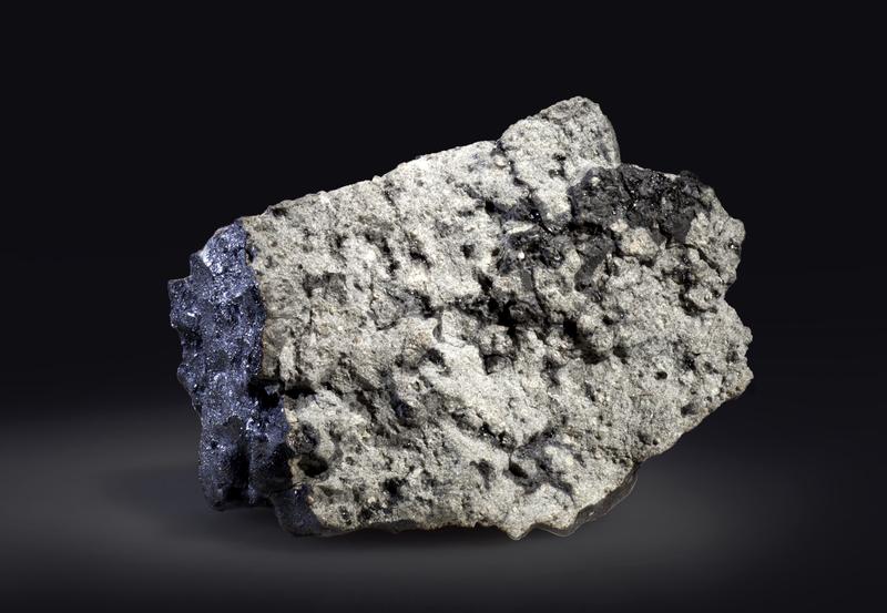 A photo of the Tissint Martian meteorite showing a hand sample that weighs 327g. Dark patches and veins on the broken surface are melt formed by a shock event that took place on Mars.