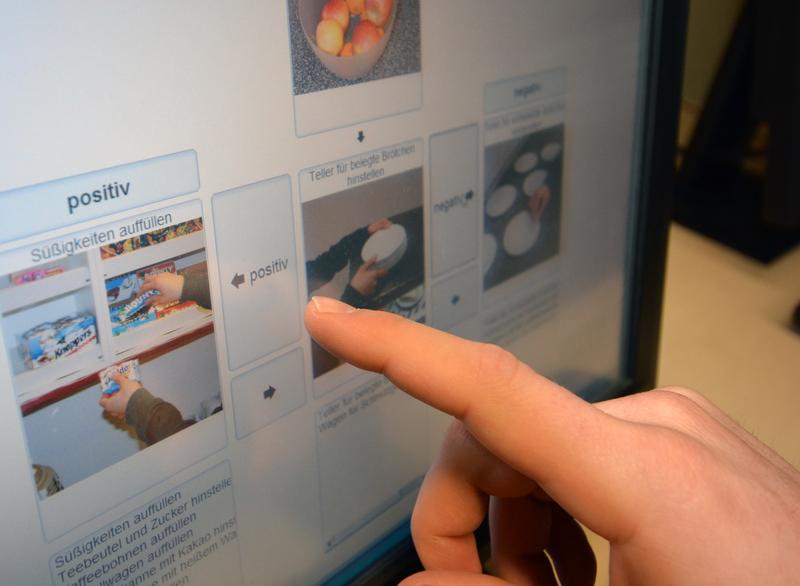 Berufstätige mit Handicap schieben und sortieren auf dem Bildschirm ihre Arbeitsabläufe und lernen damit für den Alltag im Kiosk.