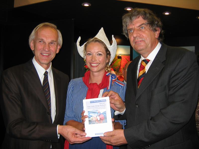 Madeleen Driessen alias Frau Antje präsentiert das Buch "Frau Antje bringt Holland" dem Direktor des Büros für Molkereiprodukte Kees Pette (links) und dem niederländischen Agrarminister Cees Veerman.