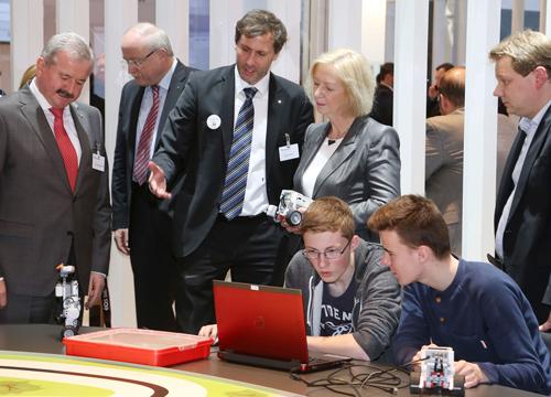 Bundesministerin Prof. Dr. Johanna Wanka und Fraunhofer-Präsident Prof. Dr. Reimund Neugbauer (li) zeigten sich beeindruckt und schauten den Schülern beim Programmieren interessiert über die Schulter