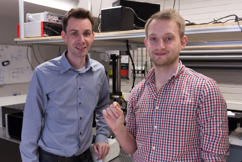 Prof. Dr. Thomas Zentgraf (links) und Masterstudent Bernhard Reineke (rechts) präsentieren im Optiklabor ihr entwickeltes nichtlineares optisches Material.