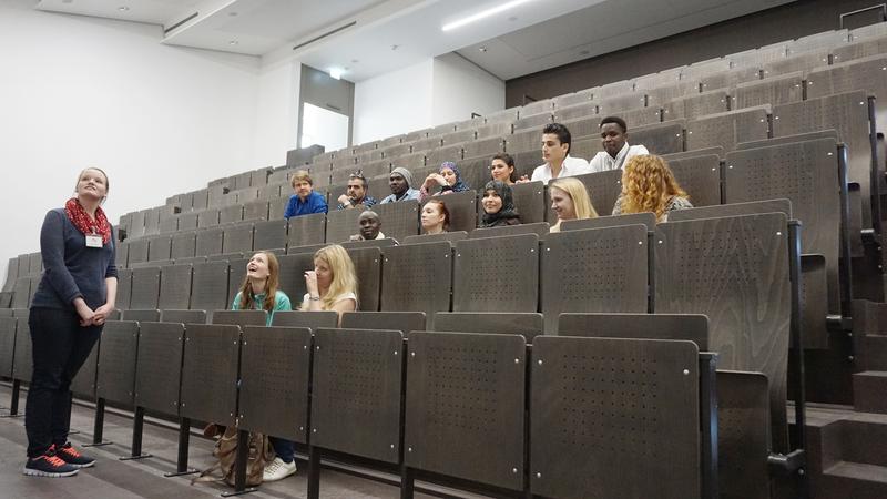 Studentinnen der Uni Hildesheim zeigen Studierenden mit Fluchterfahrung den Uni-Campus. Lehrende und Studierende arbeiten mit Asyl e.V. zusammen, um Flüchtlinge auf ihrem Bildungsweg zu unterstützen.