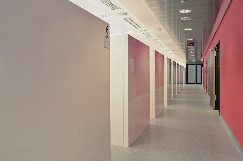 In fertigen Behandlungssaal: Links reihen sich die Behandlungsboxen aneinander. Sie gewähren den Patienten ausreichend Privatsphäre während ihrer Therapiesitzung.