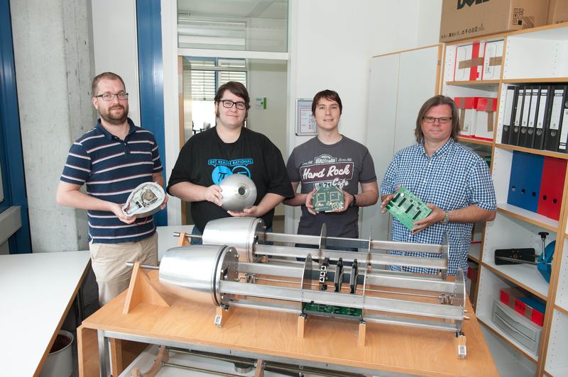 Prof. Frank Slomka, die Studenten Heiko Ehret (Projektgruppenleiter UWAVE) und Patrick Weggler sowie der Doktorand Tobias Bund präsentieren Komponenten des U-Boots