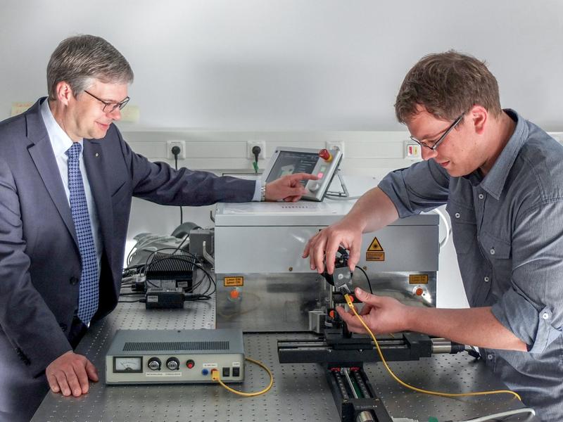 Prof. Dr. Wolfgang Viöl (links) und Preisträger Dr. Christoph Gerhard beim Justieren einer Anlage für die Laser-Plasma-Hyrbidtechnologie..