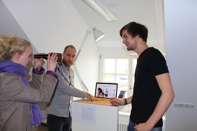 Die MID-Studenten Lucas Köhler (links) und John Moss erklären einer Ausstellungsbesucherin, wie ihr digitales Fernglas „Itto“ funktioniert.