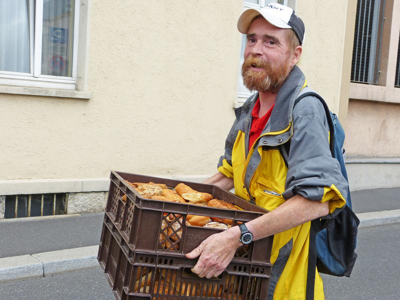 Berti trägt eine Kiste mit Backwaren von der Würzburger Tafel ins Christopherushaus in der Wallgasse. 
