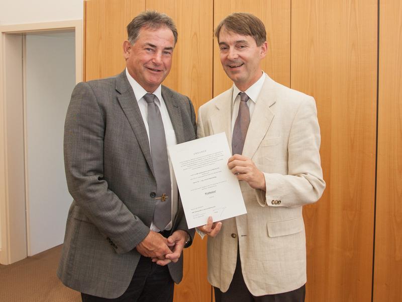 Jürgen Kretschmann (right), the Managing Director of DMT-LB, presents Ulrich Paschedag with his certificate of appointment as a Professor of the TFH