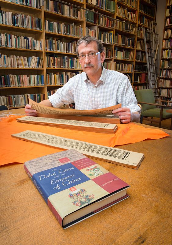 Prof. Dr. Peter Schwieger vom Institut für Orient- und Asienwissenschaften der Universität Bonn mit einer tibetanischen Schrift. Davor sein neues Buch "The Dalai Lama and the Emperor of China". 