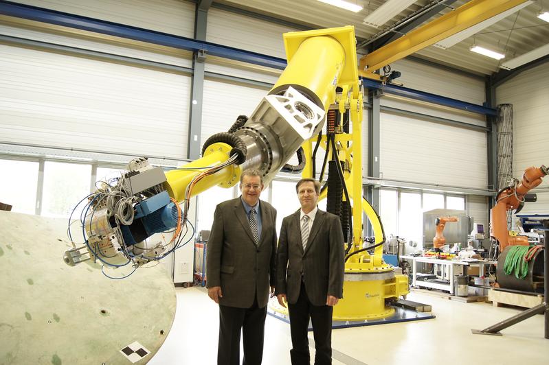  Prof. Dr. Martin-Christoph Wanner (links) vom Lehrstuhl Fertigungstechnik und Prof. Dr. Knuth-Michael Henkel vom Lehrstuhl Fügetechnik vor dem Großroboter im Technikum des Fraunhofer AGP