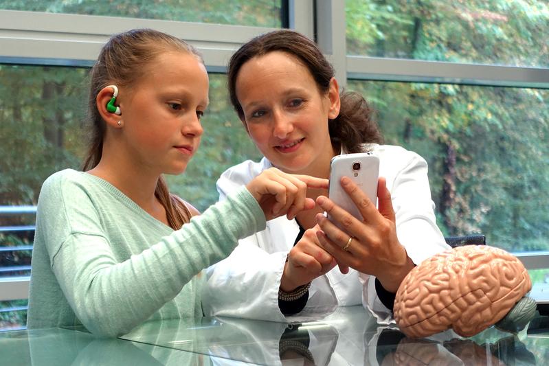 The minisensor system in future use: The sensor is placed in the ear, and a smartphone transmits the data to a computer that analyses the signals to detect epileptic seizures. 