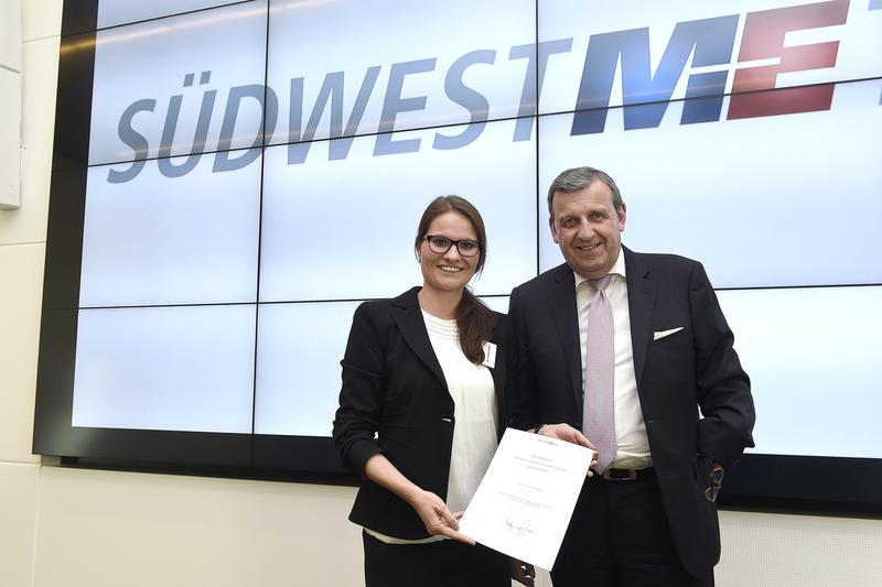 Der Südwestmetall-Vorsitzende Dr. Stefan Wolf überreicht der Freiburger Forscherin Karola Rühle einen Förderpreis. 