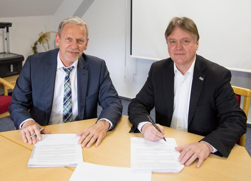Dr. Olaf Haase (l.), Referent Gesundheitsmanagement bei der IKK gesund plus, und Michael Schilling, Kanzler der Hochschule Harz, unterzeichnen den Kooperationsvertrag.