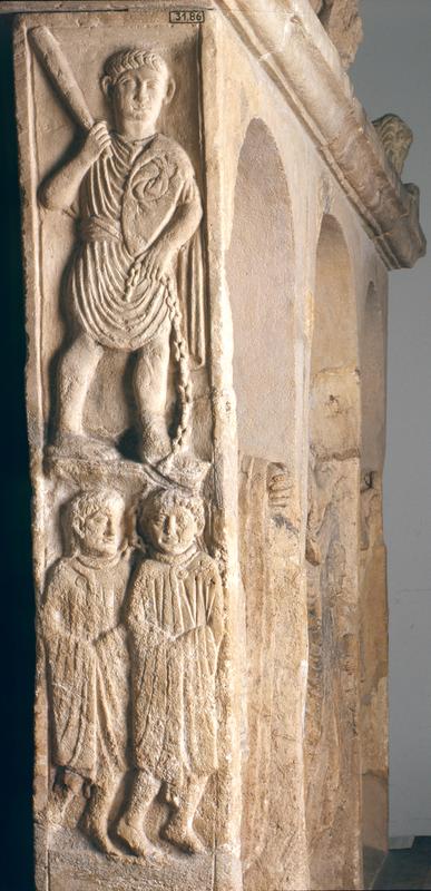 Grabstein aus Nickenich bei Mayen (etwa 50 n. Chr.):  Das Relief zeigt einen Sklavenhändler, der zwei Sklaven an einer Kette führt, um sie zu verkaufen. Es ist im LVR-Landesmuseum in Bonn zu sehen. 