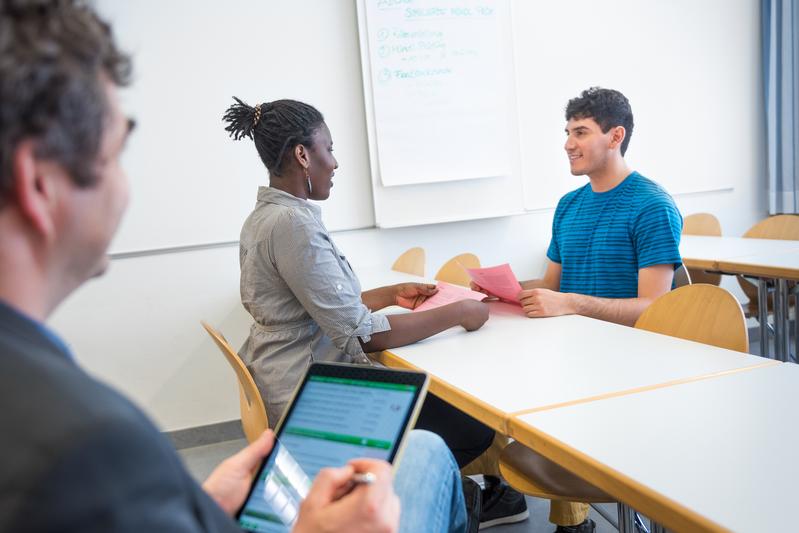 Internationale Studierende prüfen sich bei der simulierten mündlichen Prüfung als Vorbereitung auf den 1. Abschnitt der Ärztlichen Prüfung unter Beobachtung des Supervisors gegenseitig.