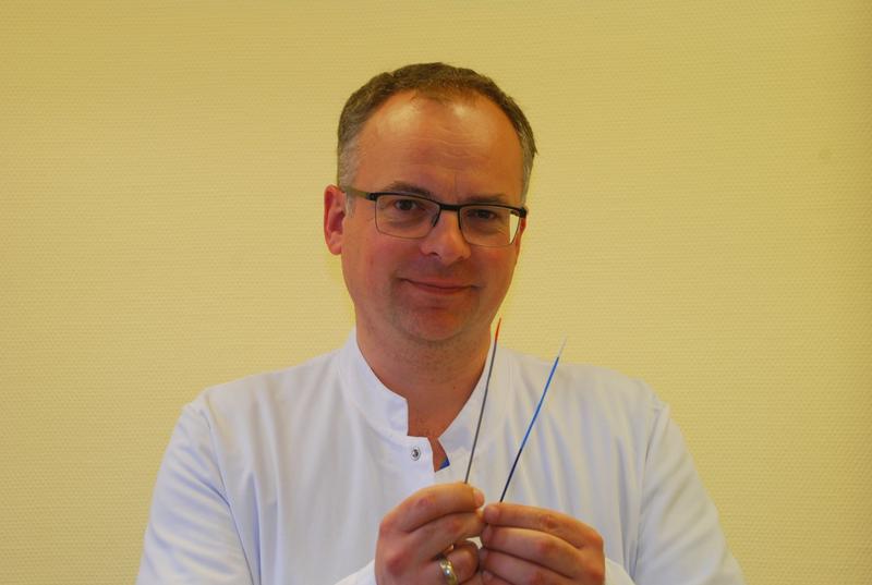 Prof. Ralf-Thorsten Hoffmann, Leiter des Bereichs interventionelle Radiologie, mit den beiden Spezial-Kathetern zur minimalinvasiven Anlage eines Dialyseshunts.