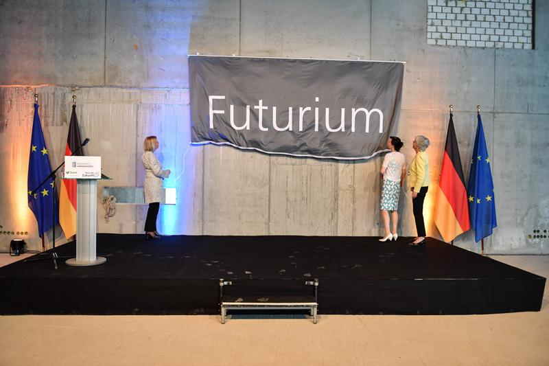 Bundesministerin Johanna Wanka zusammen mit der kaufmännischen Geschäftsführerin des Futuriums, Nicole Schneider, und Staatssekretärin Cornelia Quennet-Thielen beim Entrollen des Namens Futurium