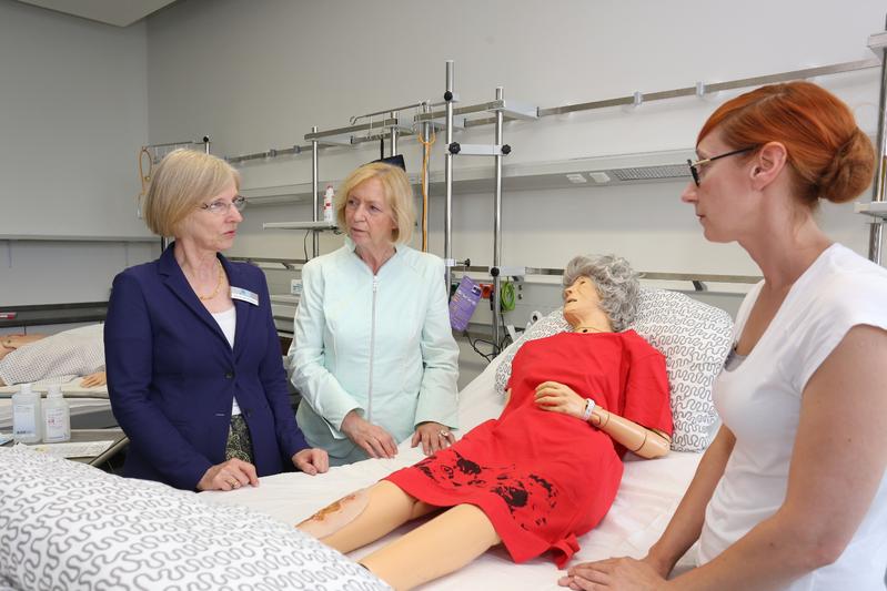 Bei der Besichtigung im SkillsLab: hsg-Präsidentin Anne Friedrichs, Bundesforschungsministerin Johanna Wanka, ein Ganzkörpersimulator und Julia Schumacher, wissenschaftliche Mitarbeiterin.
