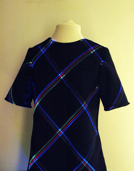 Leuchtende Fasern erzeugen wechselnde Tartan-Webmuster auf dem Kleidungsstück 