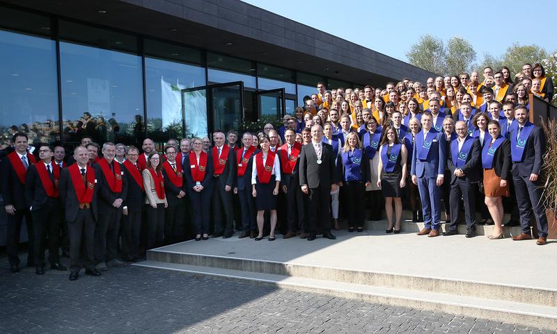 Gruppenfoto aller anwesenden Bachelor- (Orange) und Master-Absolventinnen und Absolventen (Blau) gemeinsam mit den Professoren der SRH Fernhochschule (Mittig: Rektor Prof. Dr. 