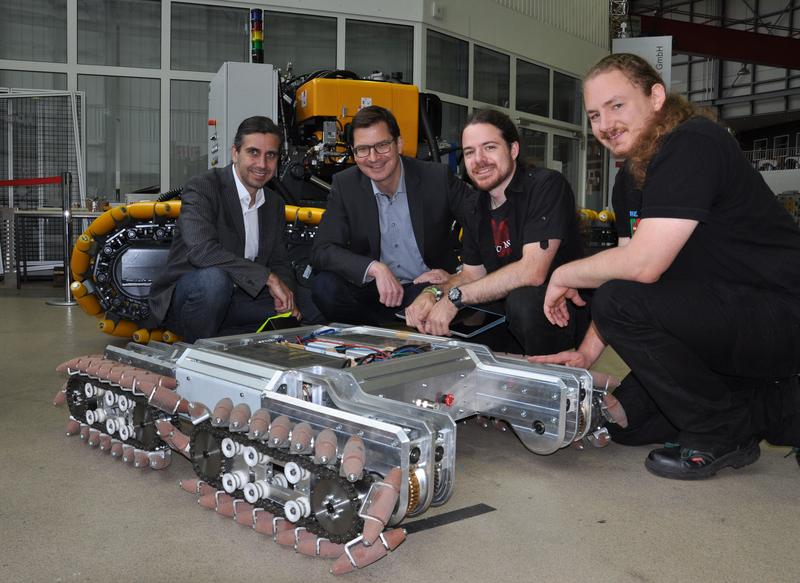 Meeting on the "Last Mile Assistant Robot" (LaMA) in BIBA-workshop (from left to right): Project supervisor Claudio Uriarte and BIBA head Michael Freitag with the students Nils Hoppe and Simon Stock.