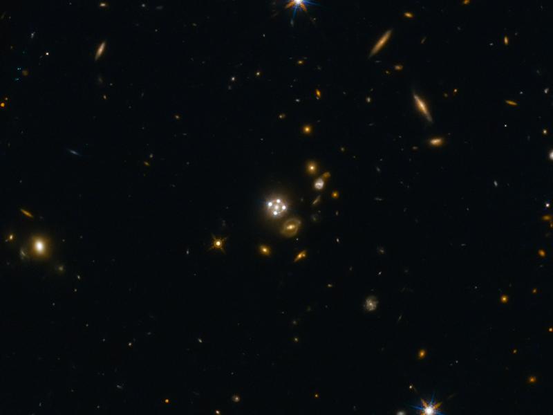 Das System HE0435-1223 (Mitte) gehört zu den fünf besten bisher entdeckten Linsenquasaren. Die Vordergrundgalaxie erzeugt vier nahezu gleichmäßig verteilte Bilder des entfernten Quasars.