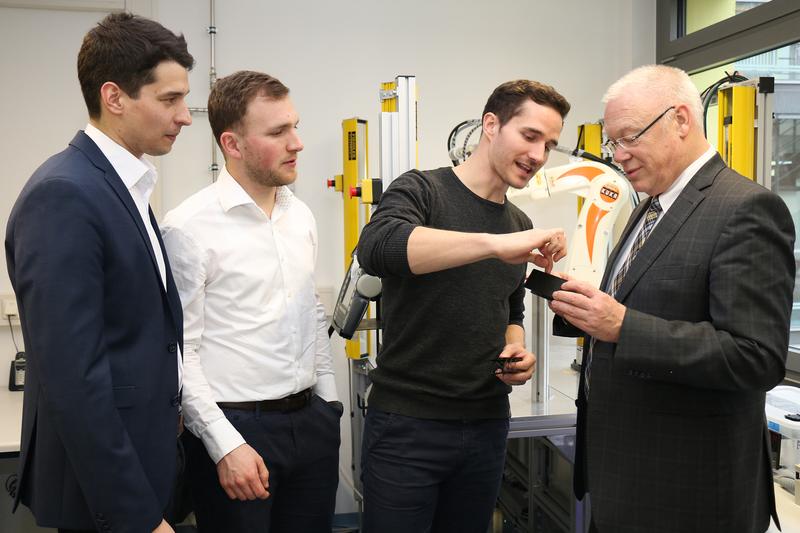 Studierende erläutern Dr. Harald Wilms (rechts), Kurator der Zeppelin Stiftung, die Ergebnisse des neuen 3D-Druckverfahrens.