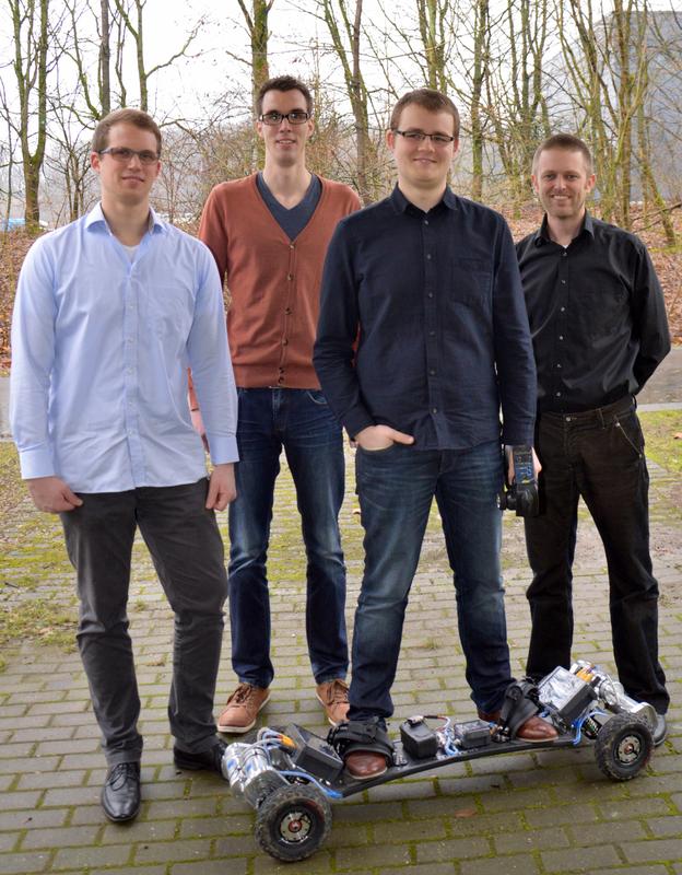 Stolz auf Mountainboard "Epos" (v.l.): Florian Wagner (Masterabsolvent), Tim Seifert (Projektarbeit), Sean William Dalton (Bachelorabsolvent) mit ihrem Professor Arno Bergmann