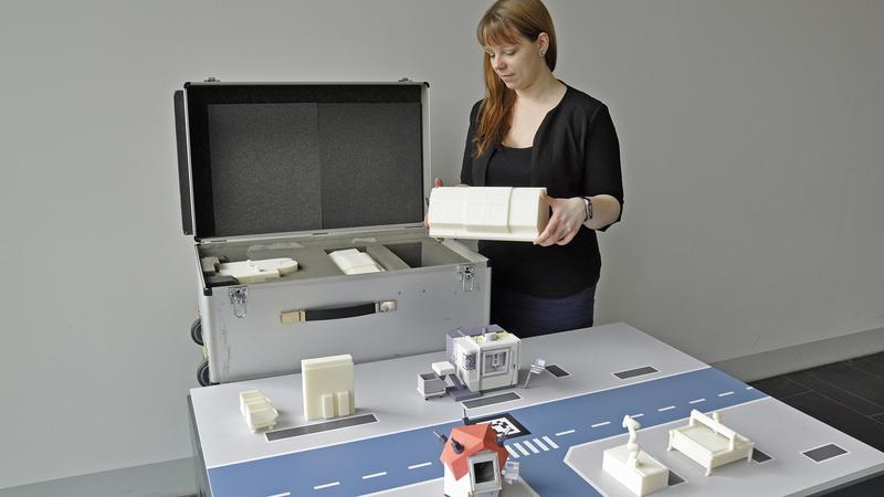 Jennifer Brade von der Professur für Werkzeugmaschinen und Umformtechnik der TU Chemnitz bereitet die Modellfabrik für ihren Messe-Einsatz vor.