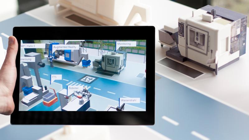 Das ist „Augmented Reality“: Hält der Betrachter ein Tablet über die Modellfabrik, werden auf dem Bildschirm automatisch weiterführende Informationen angezeigt.