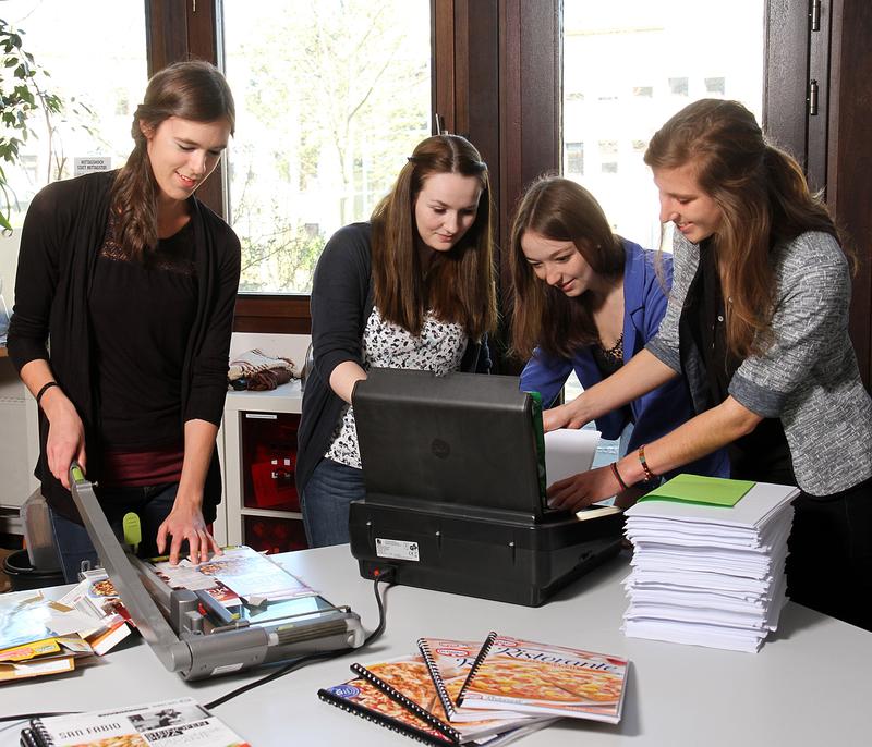 Die Studentinnen (von links nach rechts) Teresa Körber, Julie Vesque, Laura Sterle und Janika Ofterdinger stellen Blöcke aus einseitig bedrucktem Papier und Verpackungskartons her. 