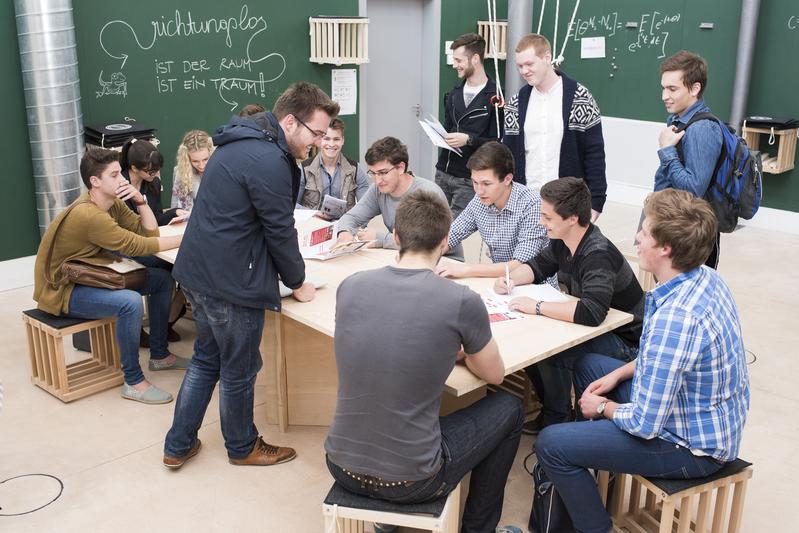Teamwork: Studierende der Uni Liechtenstein erklären den Schülern die Wirtschaftswelt.