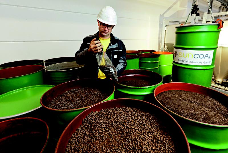 SunCoal produziert aus Biomasse in kurzer Prozesszeit Biokohle. Mitarbeiter bei Qualitätskontrolle im Technikum.