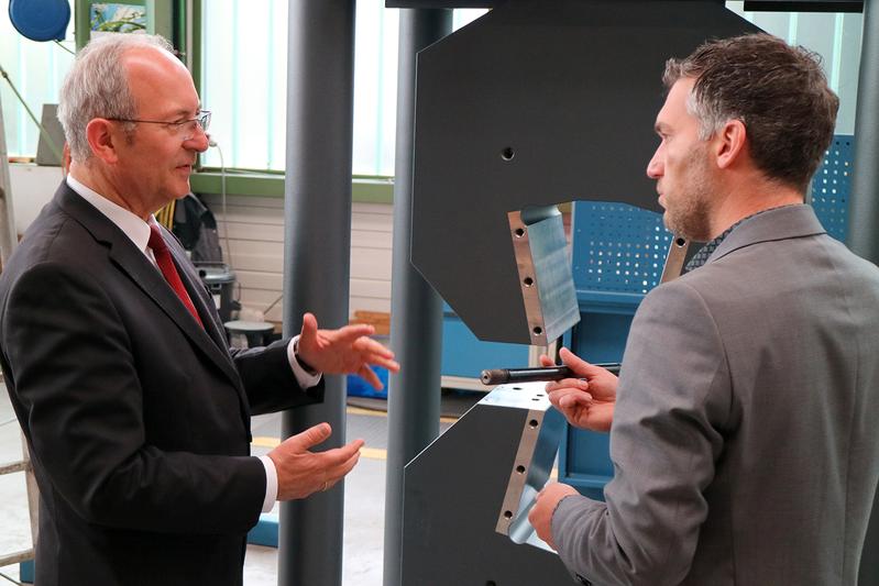 Hochschulrektor Prof. Dr. Ottmar Schneck (li.) und Bernd Locher, Geschäftsführender Gesellschafter der FORM+TEST Seidner & Co. GmbH, besichtigen die Prüfmaschinen