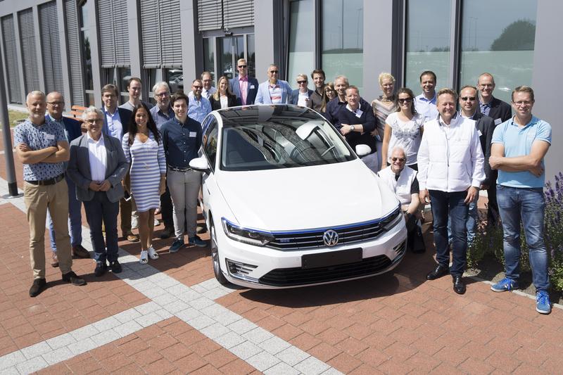 Die Teilnehmerinnen und Teilnehmer der Hansa Green Tour mit einem Passat GTE im Volkswagen Werk Emden.
