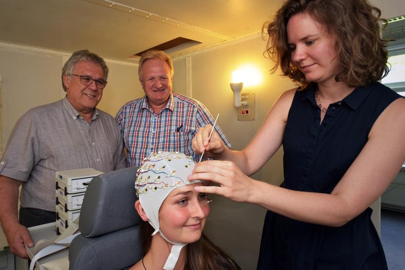Dr. Barbara Schmidt von der Uni Jena bereitet die Probandin für ein Hypnoseexperiment vor. Im Hintergrund Prof. Dr. Wolfgang H. R. Miltner (l.; Uni Jena) und Dr. Ewald Naumann (Uni Trier).