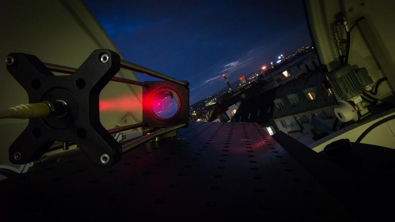 Sendestation mit rotem Justagelaser im Hedy Lamarr Teleskop am Dach des Instituts für Quantenoptik und Quanteninformation der ÖAW mit Blick in Richtung der Empfangsstation im Norden Wiens. 