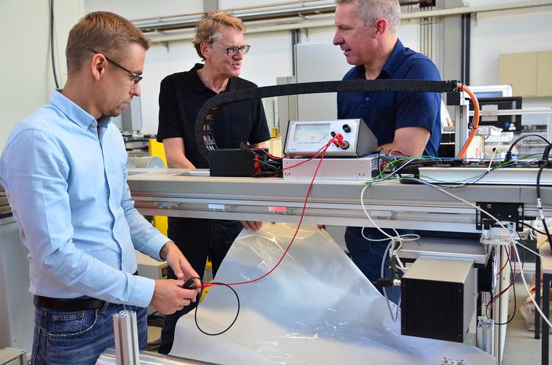 Sascha Wagner (l.) und Jürgen Gröninger (r.) vom Laserzentrum der FH Münster besprechen mit Siegfried Hartmann von EMPAC, wie sich die Folie in die Pilotanlage integrieren lässt.