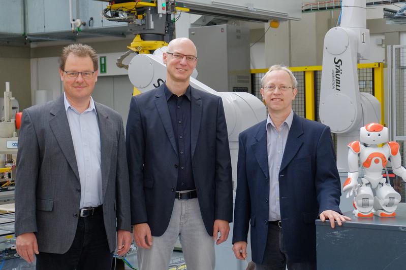 Drei Professoren und ein Nao im Robotiklabor: Prof. Dr. Dirk Rokossa, Prof. Dr. Siegmar Lampe und Prof. Dr. Clemens Westerkamp, Sprecher (v.l.) leiten das Kompetenzzentrum „I4os - Industrie 4.0"