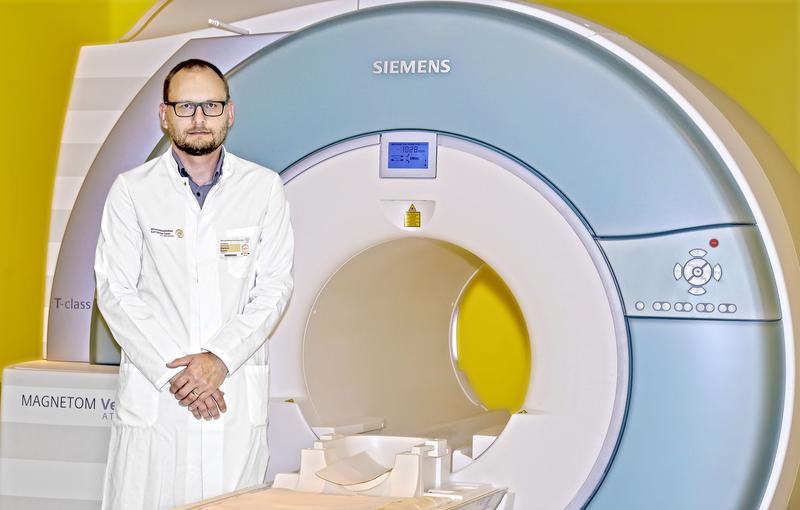 Prof. Markus Donix vor einem Magnetresonanztomographen. Dieses Bildgebungsverfahren hat für wichtige Impulse in der Hirnforschung gesorgt.