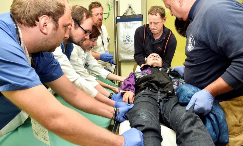 Die Einsatzkräfte der Feuerwehr sowie Ärzte und Pflegekräfte des Uniklinikums lagern gemeinsam einen Patientendarsteller, der in der Notaufnahme eingetroffen ist.