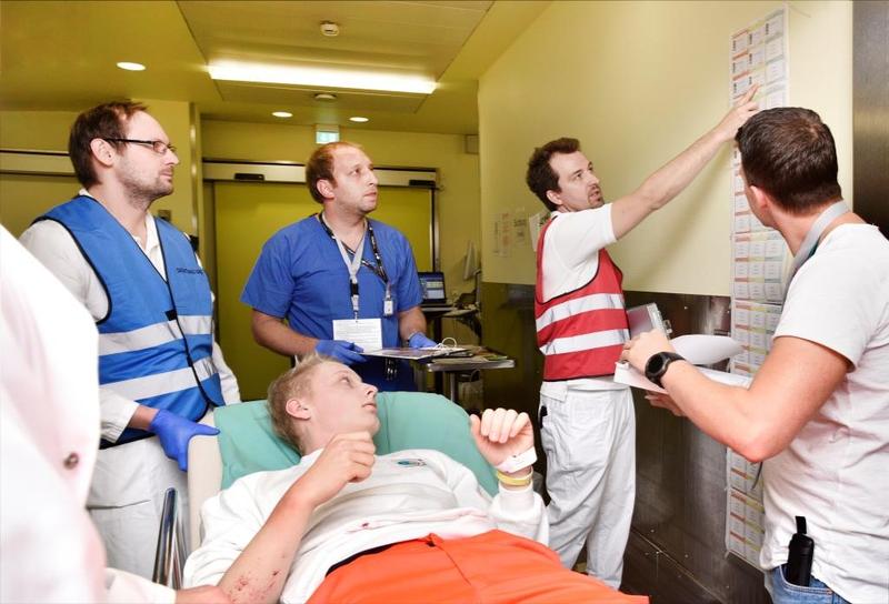 PD Dr. Christian Kleber (rote Weste) zeigt Pflegekräften und Ärzten des Uniklinikums die bisherige Anzahl an eingelieferten Patienten. 