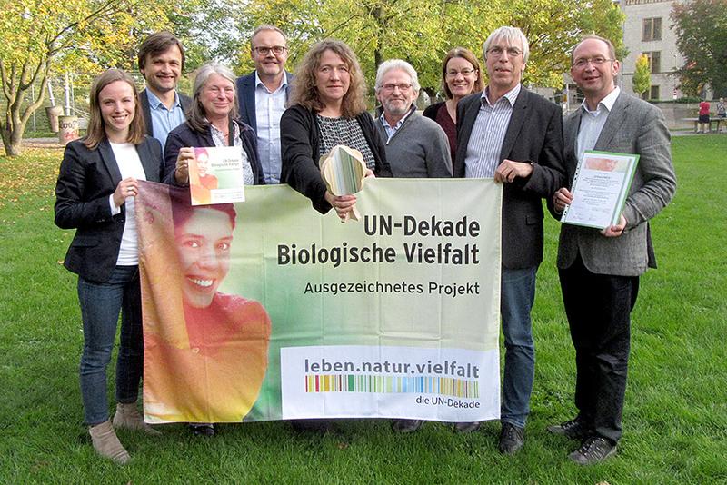 Matthias Herbert (re.) vom Bundesamt für Naturschutz (BfN) überreichte am 19. Oktober in Bielefeld dem Urban NBS-Team die Auszeichnung der UN-Dekade Biologische Vielfalt.