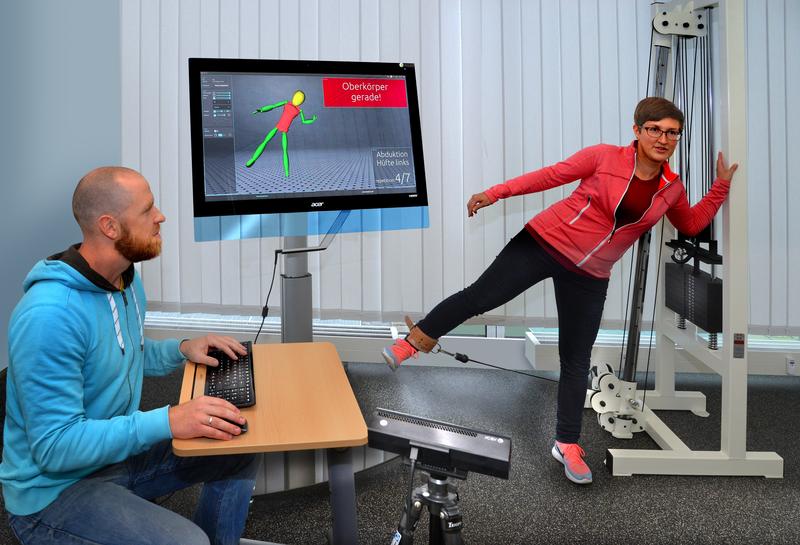 Echtzeit-Feedback am Display: Lars Lehmann von der Professur Digital- und Schaltungstechnik der TU Chemnitz testet das neue Therapieassistenzsystem mit seiner Kollegin Julia Richter im Labor.