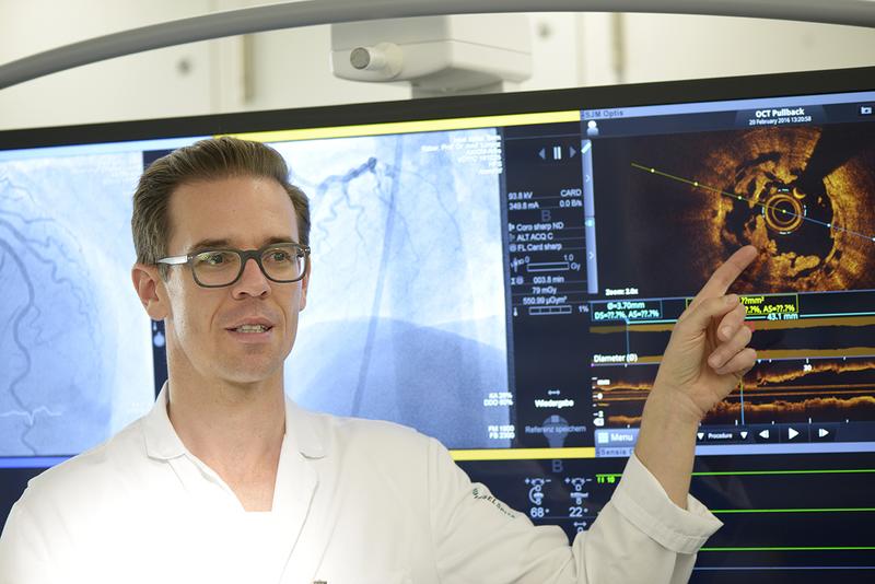 Prof. Lorenz Räber zeigt im Herzkatherlabor des Universitätsspitals Bern am Monitorbild die Einbrüche des Stentgerüsts ins Innere des Gefässes.