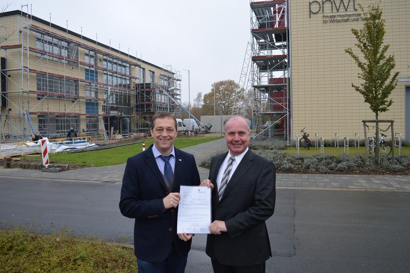 Präsident Prof. Dr. Ludger Bölke (li.) und Studienbereichsleiter Prof. Dr.-Ing. Ulrich May (re.) vor den beiden neuen Laborgebäuden